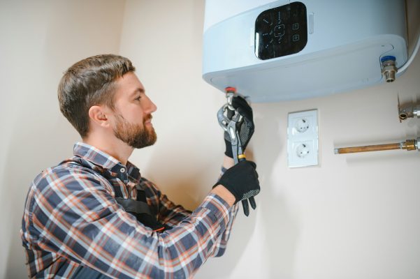 worker set up central gas heating boiler at home